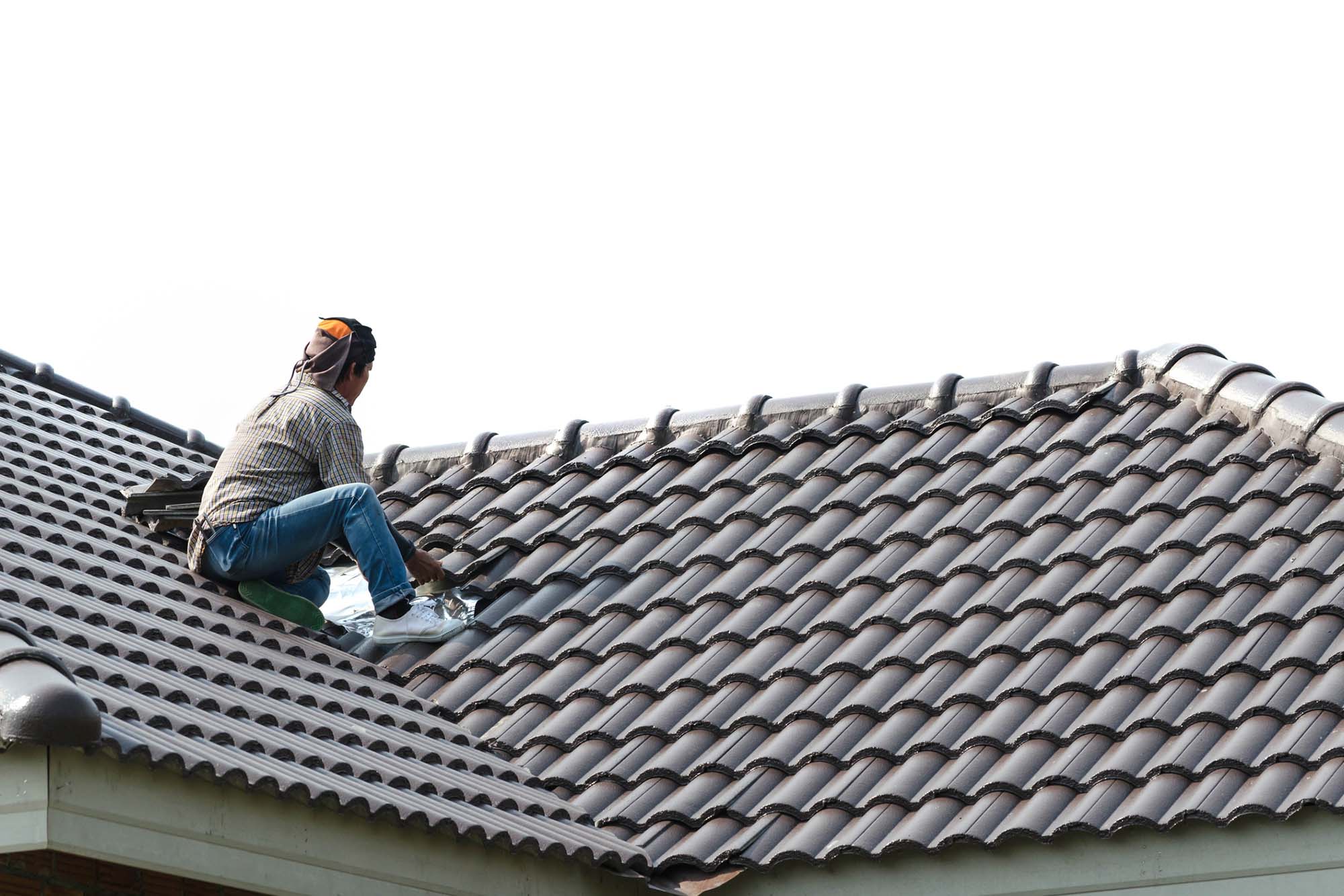 Man sitting on roof fixing tiles
